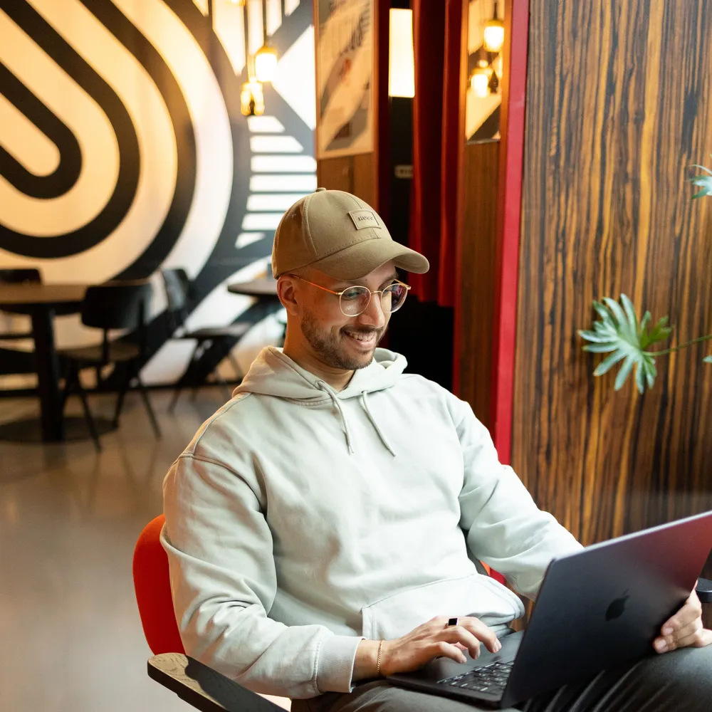 Dilshan Kelsen, Gründer von Webigo e.U., arbeitet konzentriert an seinem Laptop.